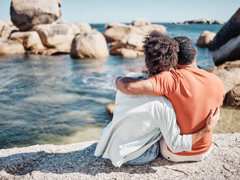 Couple en train de partager une tasse de thé dans une pièce chaleureuse, lumière douce, ambiance d’intimité bienveillante
